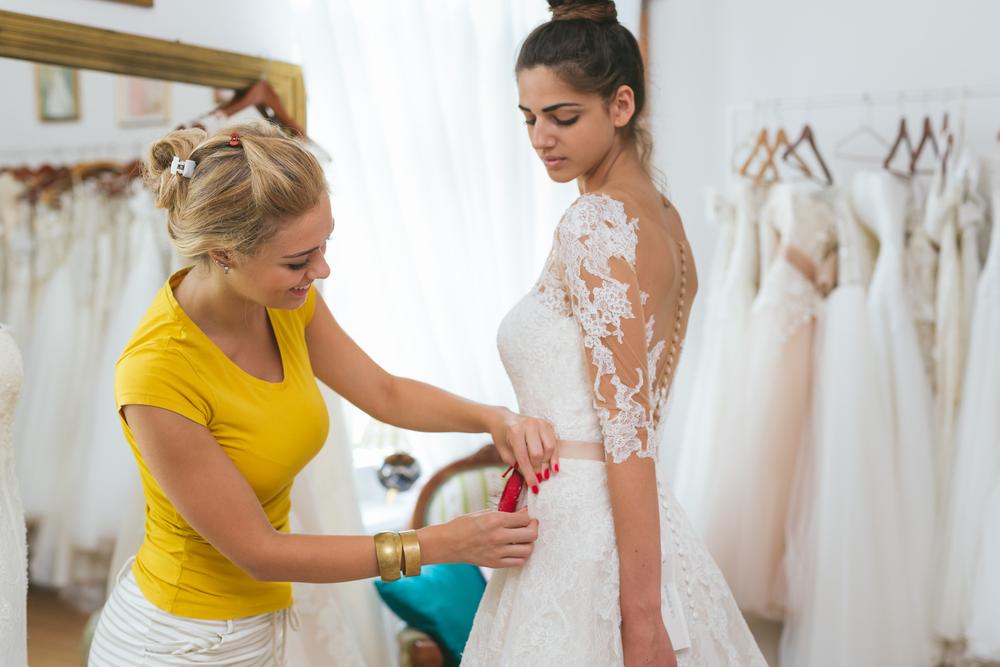 Designer taking measurements for a wedding dress