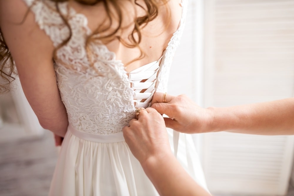 A seamstress adjusting a wedding dress at Rita Bridal.