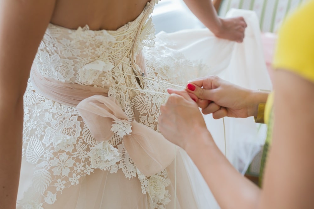 A seamstress adjusting a wedding dress at Rita Bridal.