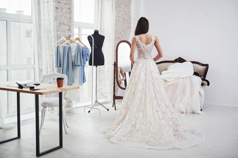 A seamstress adjusting a wedding dress at Rita Bridal.