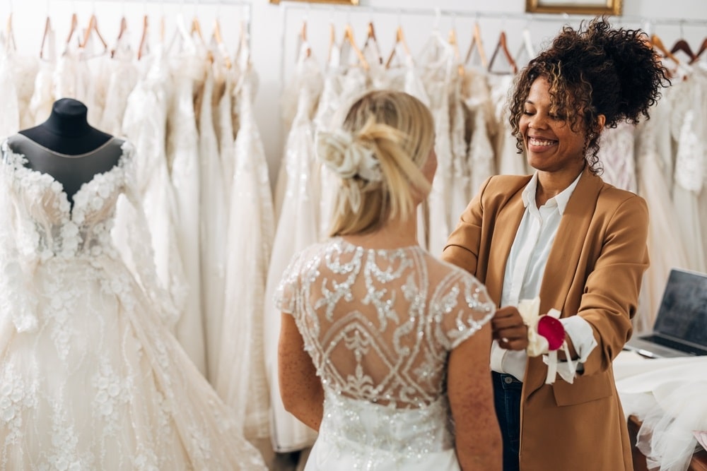 A seamstress adjusting a wedding dress at Rita Bridal.