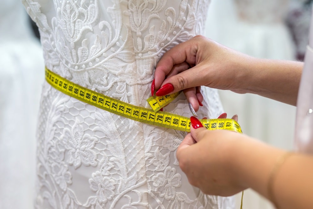 Bride having her wedding dress altered in a bridal boutique.