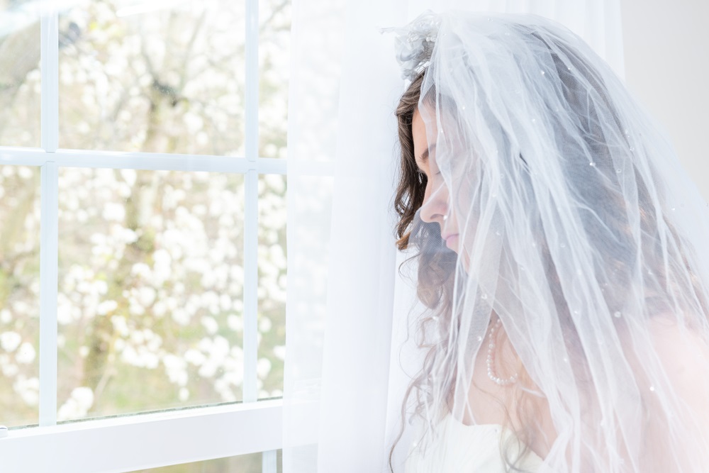 A bride contemplating her wedding dress choice with a professional seamstress ready to offer solutions.