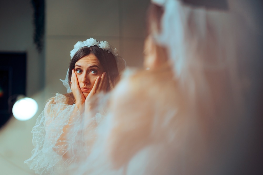 A bride contemplating her wedding dress choice with a professional seamstress ready to offer solutions.