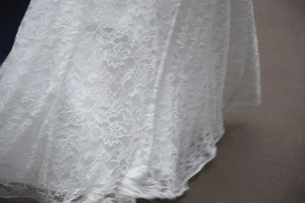 A seamstress expertly hemming a wedding dress for the perfect bridal fit